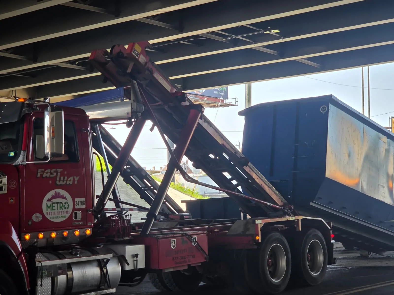 Roll-off truck delivering a container